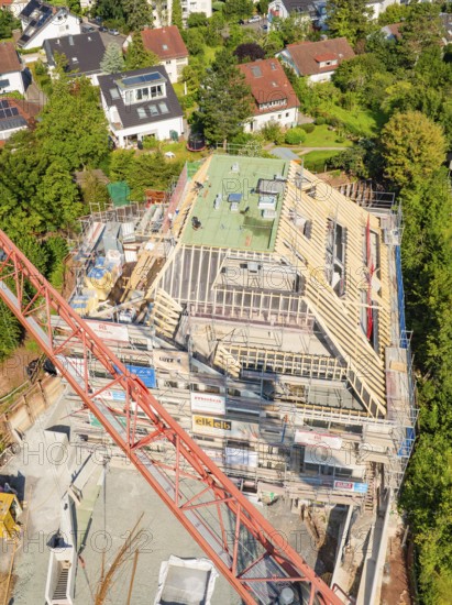 Construction site with partially erected roof, crane and neighboring houses in a residential area, carpentry construction, roof extension, renovation, Stuttgart, Germany
