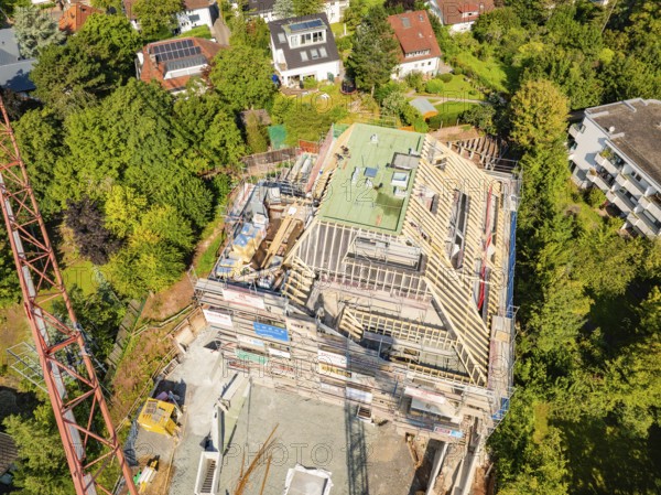 Roof of a house under construction with crane and surrounding houses in the countryside, construction site of a carpentry workshop, roof extension, renovation, Stuttgart, Germany