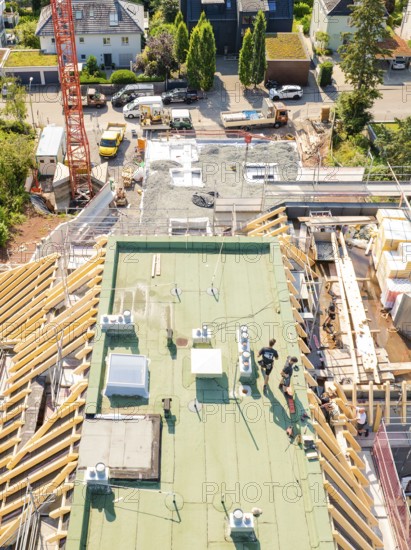 View of the upper construction site with workers and building materials, surrounded by urban landscape, carpentry construction, roof extension, renovation, Stuttgart, Germany
