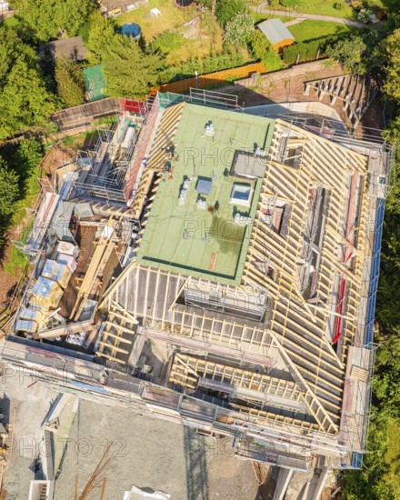 Bird's eye view of a building under construction in a green city scene, carpentry construction site, roof extension, renovation, Stuttgart, Germany
