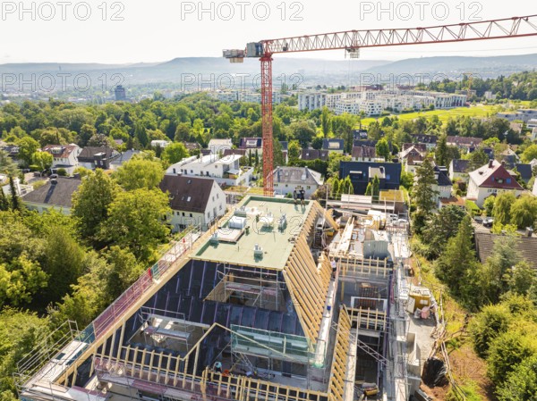 View from above of a construction site with crane and surrounding residential buildings and trees, construction site of a carpentry workshop, roof extension, renovation, Stuttgart, Germany