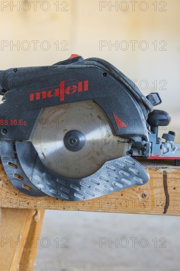 Close-up of a black and red circular saw on a wooden table, carpentry construction, roof extension, renovation, Stuttgart, Germany