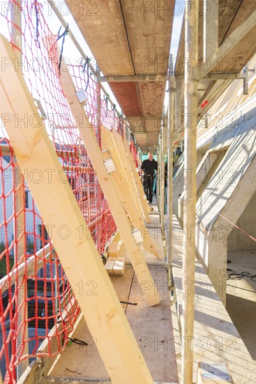 Close area of scaffolding with red safety nets and wooden struts, carpentry construction, roof extension, renovation, Stuttgart, Germany