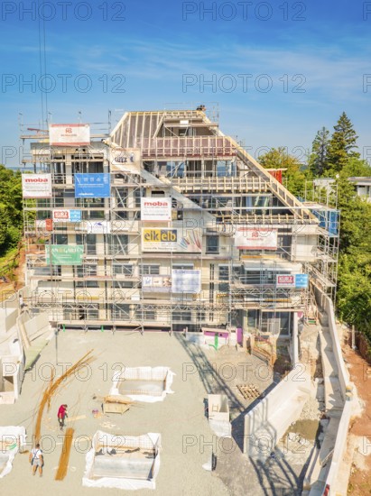 Construction site of a large building with several floors, surrounded by trees and scaffolding, construction site of a carpentry, roof extension, renovation, Stuttgart, Germany