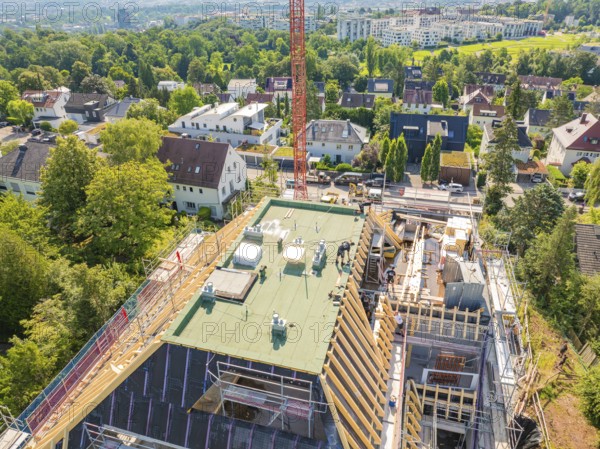 Panoramic view of a building under construction with crane and green surroundings, carpentry construction site, roof extension, renovation, Stuttgart, Germany