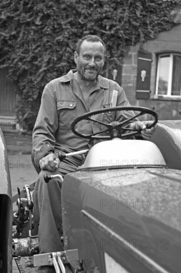 Farmer on his Schlüter tractor, black and white, Tauchersreuth, Middle Franconia, Bavaria, Germany