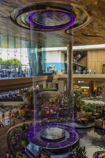 Artificial, brightly lit waterfall, magic waterfall, plunging from ceiling into a water basin, Iconsiam shopping center, Bangkok, Thailand's metropolis