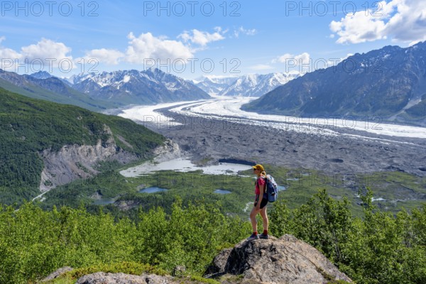 Young woman enjoying the view, view of impressive mountain landscape with Matanuska glacier and glaciated mountain peaks, Lion's Head, Chugach Mountains, Alaska