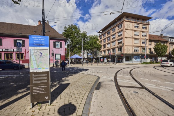 Site plan, public city map, sign for the building, general architecture, commercial buildings, houses, residential buildings, overhead lines, tram tracks, access to the pedestrian zone, blue sky, cumulus clouds, intersection of main street with Grossherzog-Friedrich-Straß, Kehl, Upper Rhine Plain, Ortenaukreis, Baden-Württemberg, Germany