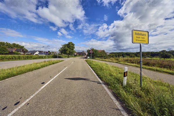 Town entrance sign, general development, building, road, guide post, trees, grass, forest, blue sky, cumulus clouds, district road K5329, Hanauerlandstraße, district of Hohnhurst, Kehl, Upper Rhine Plain, Ortenaukreis, Baden-Württemberg, Germany