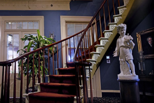Elegant wooden staircase with sculpture in a historic interior, zero