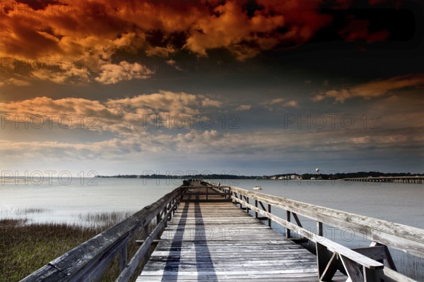 Long pier under a dramatically colored evening sky with clouds, Hunting Island, South Carolina, USA