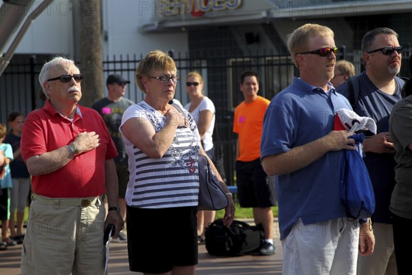 People at the entrance to the Kennedy Space Center during the national anthem, Merritt Island, Florida, USA