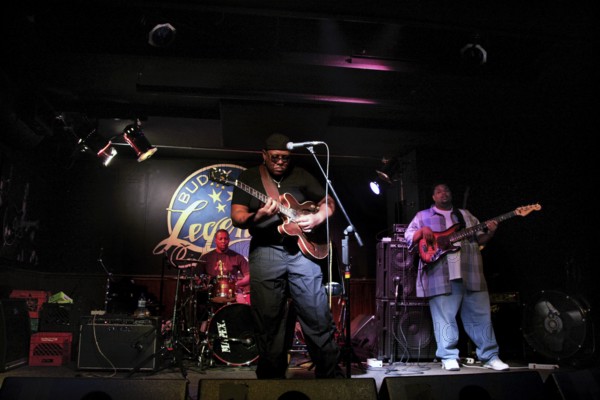 Blues musicians perform vividly on a club stage, accompanied by intensive guitar and drum music, Chicago, Illinois, USA