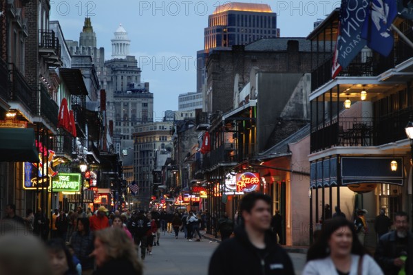 Evening atmosphere on Bourbon Street with illuminated shops and people on the street, New Orleans, Louisiana, USA