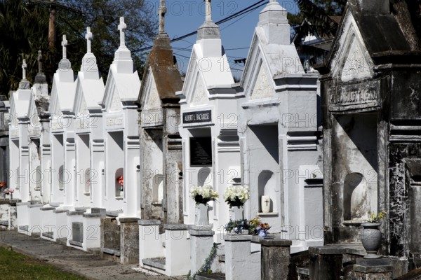 Row of white graves in Gothic style in a cemetery