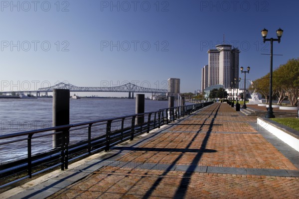 Promenade with high-rise building on the riverbank under clear sky, New Orleans, Louisiana, USA