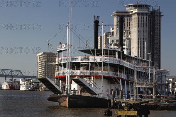 Paddle steamer against an urban backdrop on the riverbank, New Orleans, Louisiana, USA