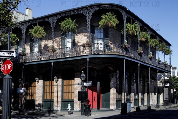 French Quarter corner building with decorated balconies and hanging plants, New Orleans, Louisiana, USA