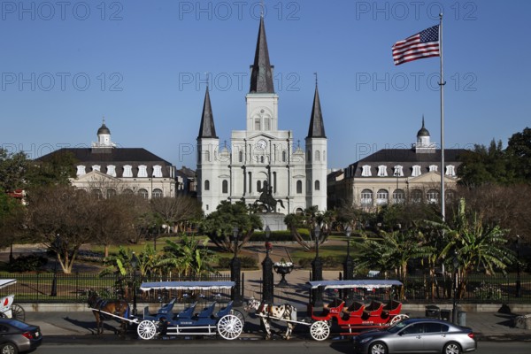 St. Louis Cathedral with carriages in the foreground and a waving flag, New Orleans, Louisiana, USA