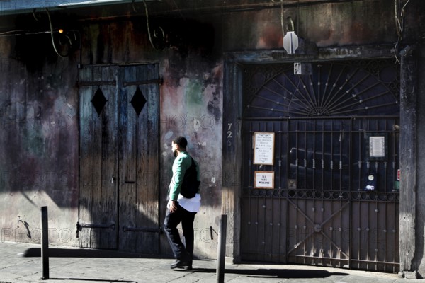 Ancient building with wall art and passing man, Preservation Hall, New Orleans, Louisiana, USA