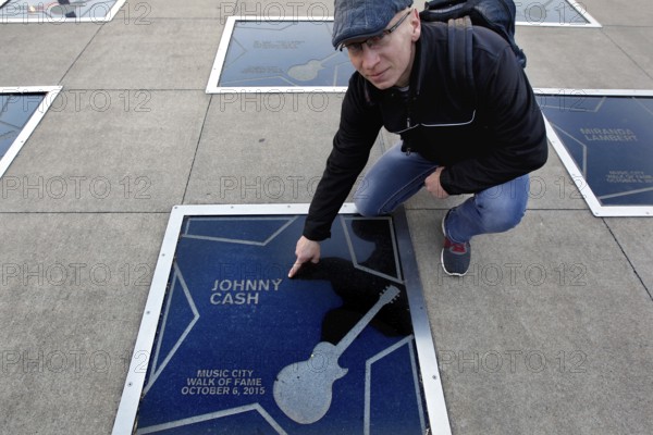 Man points at Johnny Cash's star on the Music City Walk of Fame, Nashville, Tennessee, USA