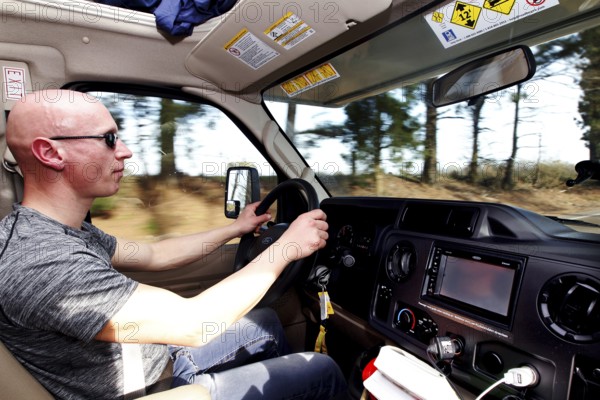 A man drives an RV on a tree-lined road, Natchez, Mississippi, USA