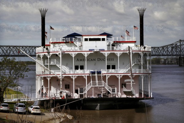 Historic paddle steamer docked on the riverbank, a bridge in the background, Natchez, Mississippi, USA