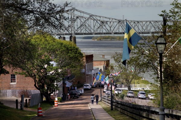 Street view in Natchez with bridge in background and flags along the road, Natchez, Mississippi, USA