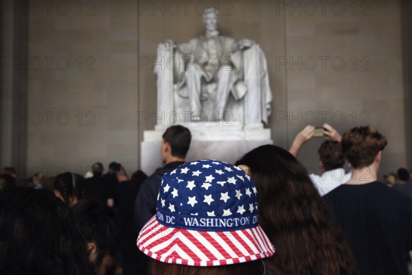 Visitors look at the Lincoln statue, some wearing patriotic clothes, Washington D.C, USA