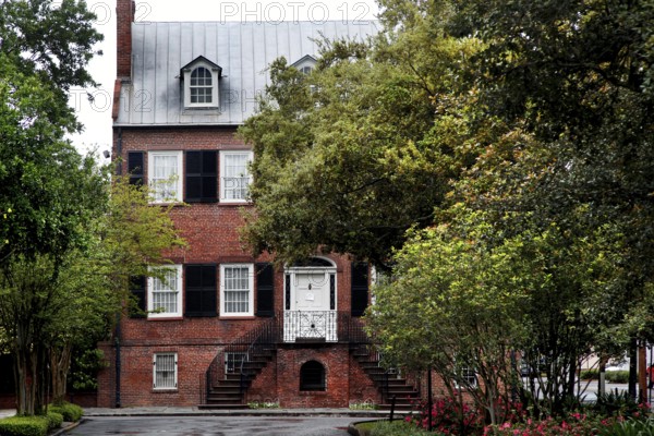 Brick house with Georgian architecture surrounded by trees and plants, Savannah, Georgia, USA