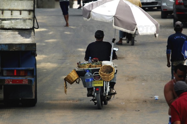 Oyster seller on a motorcycle on a street in Oulidia, Oulidia, Doukkala-Abda, Morocco