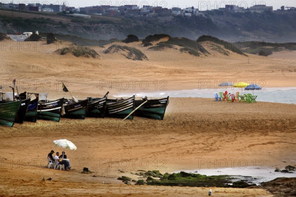 Expansive beach view with boats and people in Oulidia, Oulidia, Morocco