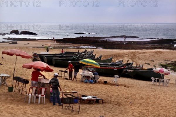 Fishing boats and food stalls in cloudy weather on Oulidia beach, Oulidia, Doukkala-Abda, Morocco
