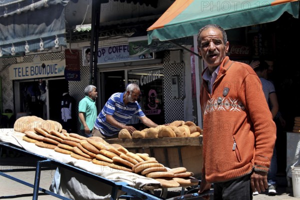 A bread seller presents his goods on the lively Place Mohammed VI in Moulay Idris, Moulay Idris, Fès-Meknès, Morocco