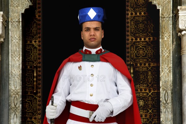 Guard wearing traditional uniform in front of the Hassan Mausoleum in Rabat, Rabat-Salé-Kénitra, Morocco