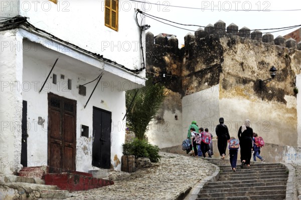 People walk through historic Medina and climb a flight of stairs, Tangier, null, Morocco