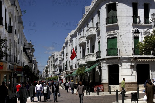 Bustling Avenue Mohammed V in Tetouan with white buildings and passers-by, Tetouan, Morocco
