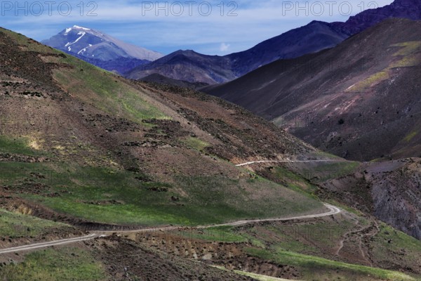 Barren mountain landscape with green valleys and a winding road in the High Atlas, Ouarzazate, High Atlas, Morocco