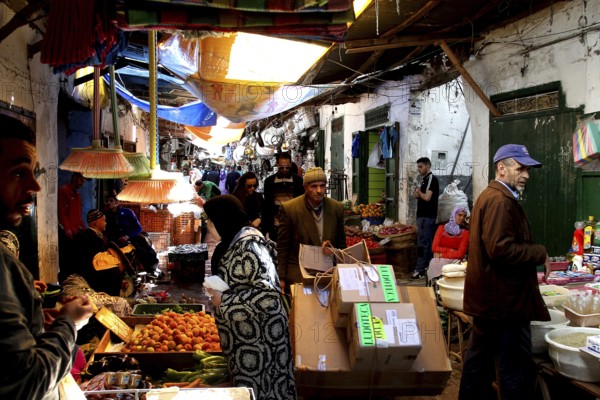Bustling vegetable market with sellers and customers in a busy market alley, Tetouan, Medina, Morocco