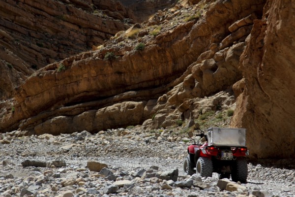 A quad bike surrounded by rocky cliffs in the gorge landscape, Tal, Tizgui n'Ouadda