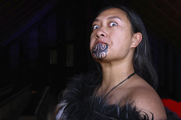 Woman with traditional face moko posing in traditional Maori clothing, Waitangi, New Zealand