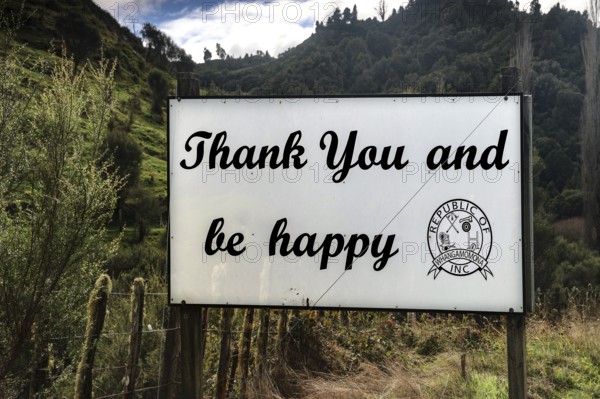 Sign in Whangamomona with the message 'Thank you and be happy' in a natural setting, Whangamomona, null