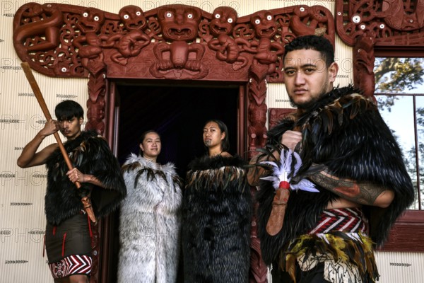 Group of Maori in traditional clothing in front of ornate entrance, Waitangi, New Zealand