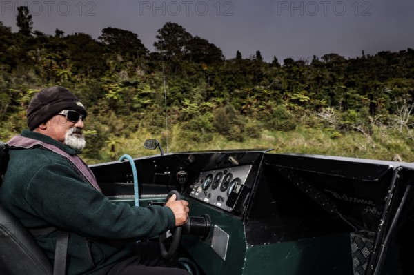Man rides a motor boat along the Whanganui River through green nature, Whanganui River, Manawatu-Wanganui, New Zealand