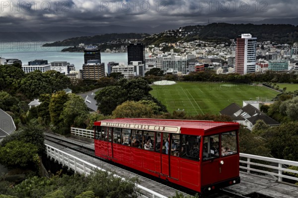 Red cable car overlooks Wellington and its green hills as well as the city, Wellington, New Zealand