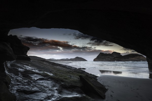 Dramatic coastal scene at Wharariki Beach with a view of the ocean from a cave, Wharariki Beach, Tasman, New Zealand