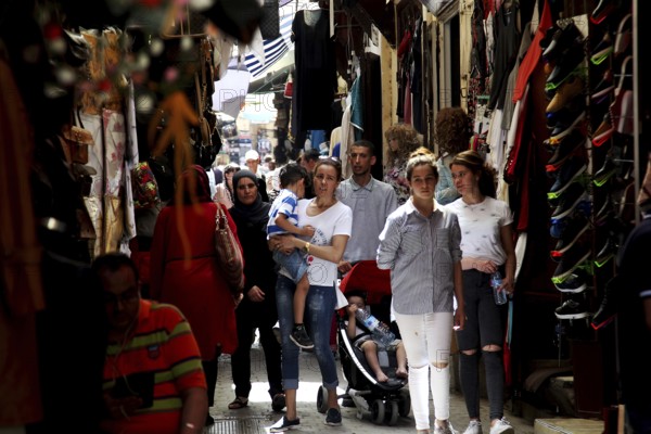 People stroll through a narrow market alley with traditional shops, Fez, Fez el Bali, Morocco