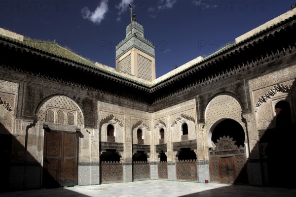 Medersa Bou Inania courtyard with arcades and blue sky in the background, Fez, Fès-Boulemane, Morocco