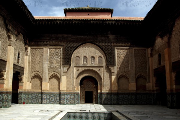 The magnificent courtyard of Medersa Ben Youssef with ornate architectural elements, Marrakech, Morocco